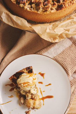 A top view shot of a delicious slice of apple pie on a plate topped with crumble, nuts and  creamの写真素材