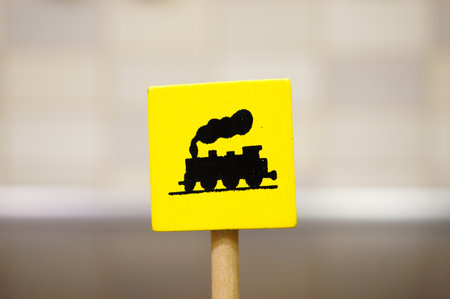 A closeup shot of a yellow wooden toy sign with a train iconの写真素材
