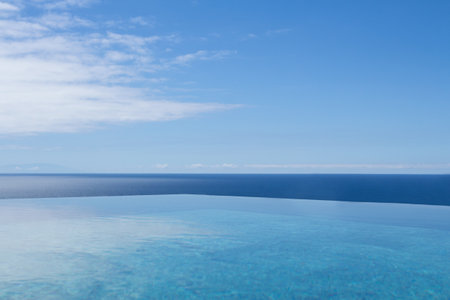 A blue sea with a clear sky with few clouds