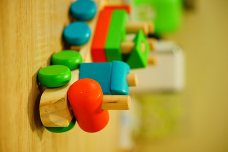 A vertical closeup shot of a toy wooden train on a wooden surfaceの写真素材