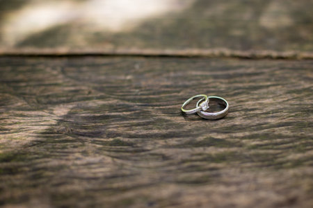 A closeup shot of wedding rings for a man and woman on a wooden surface -the concept of marriage