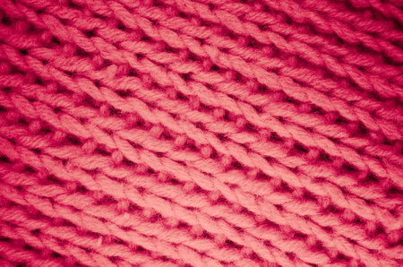 A closeup shot of a handmade pink colored wool knitted fabricの写真素材