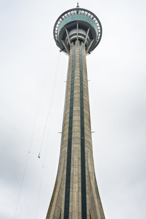 A vertical low angle shot of Macau Tower under a cloudy grey sky - perfect for mobileのeditorial素材