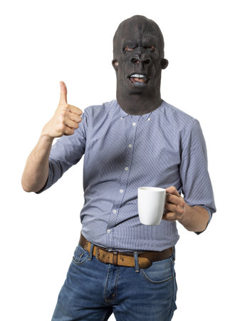 A male in a black angry mask holding a white cup and showing the like sign