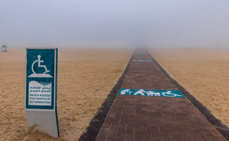 A closeup shot of a sign with access limitation on Jumeirah beach under fog in Dubai UAE