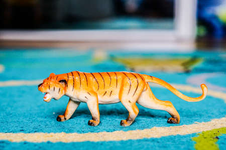 A closeup shot of a tiger figurine on a blue rugの写真素材