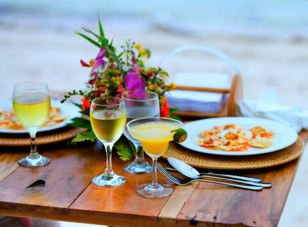 A selective focus shot of a date table with delicious food and alcoholic drinksの写真素材