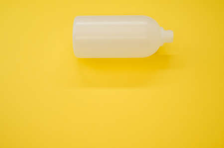 A closeup shot of a plastic bottle on a yellow backgroundの写真素材