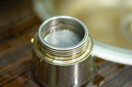 Metal bottom of a coffee cooker in soft focus. Horizontal high angle view.