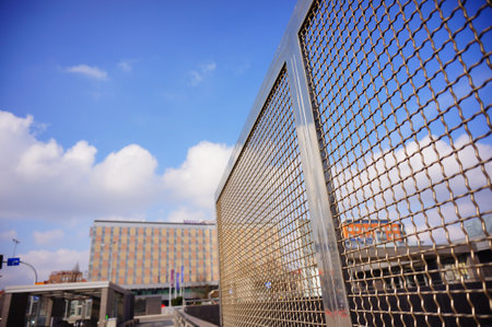 POZNAN, POLAND - Mar 05, 2020: Close up of a metal grid fence in the city center. Mercure Hotel in...