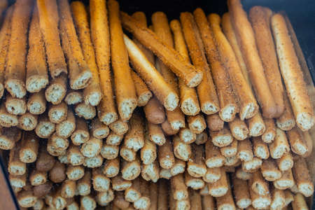 A closeup shot of a pile of pretzel sticks that have been cut in a clear containerの写真素材