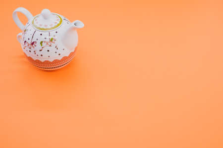 A top view of teapot isolated on an orange backgroundの写真素材