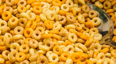 A closeup shot of fruity breakfast cereal with a silver spoon