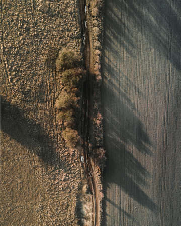 An aerial shot of a field with beautiful scenery of sunset
