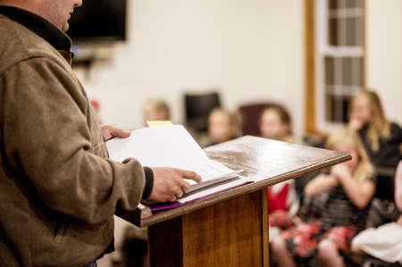 A selective focus shot of a person reading a book from the tribuneの写真素材