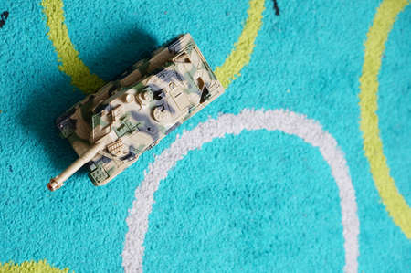 An overhead shot of a tank toy on the blue surface with drawings