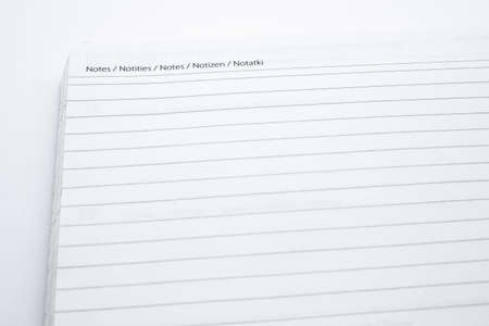 A closeup shot of an opened notebook put on a white surface