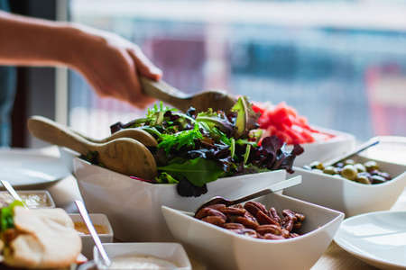 A female hand taking salad from a bowlの写真素材