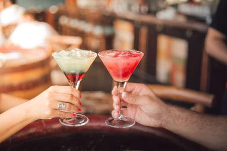 A selective focus shot of hands holding delicious cocktailsの写真素材