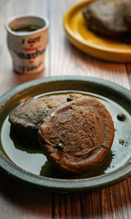 A vertical shot of delicious torrejas de pinol  placed on a plate with a blurred background