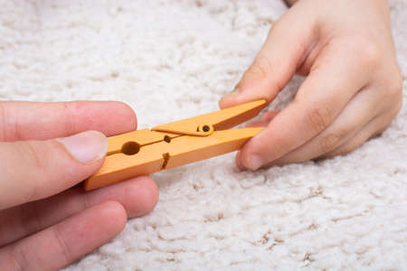 A closeup shot of two people holding a clothespinの写真素材