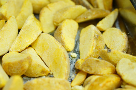 A closeup shot of frozen chopped potatoes in an oven dishの写真素材