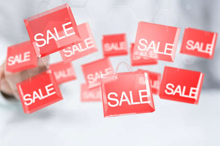 A closeup shot of a person presenting a virtual projection of red sale boxesの写真素材