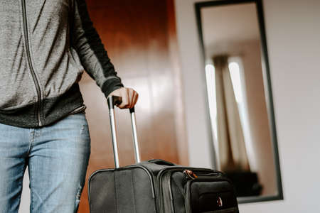 A selective focus shot of a female with a black suitcaseの写真素材