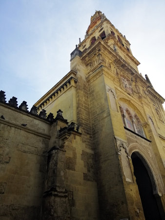 A low angle shot of a bell tower in Great Mosque-Cathedral of CÃ³rdoba in Spain with a cloudy blue sky in the backgroundのeditorial素材