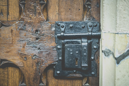 A metal black metal on an old wooden door