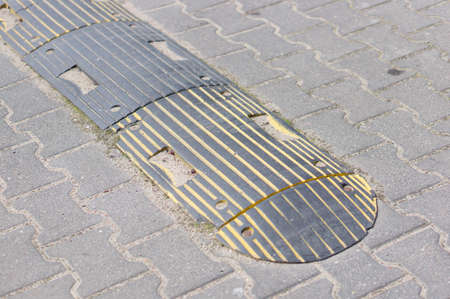 A black speed bump in the street during daytime