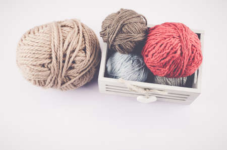 A high angle shot of colorful wools in a box on a white backgroundの写真素材