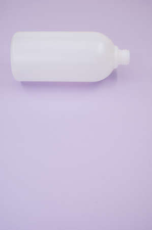 A vertical shot of a plastic bottle on a purple backgroundの写真素材