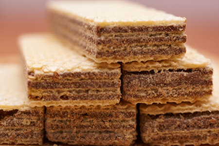 A closeup of delicious crispy wafers filled with chocolate on a wooden board