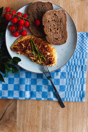 A top view of omelet, cherry tomatoes and bread - a perfect breakfast