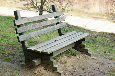 A wooden bench surrounded by grass in the park