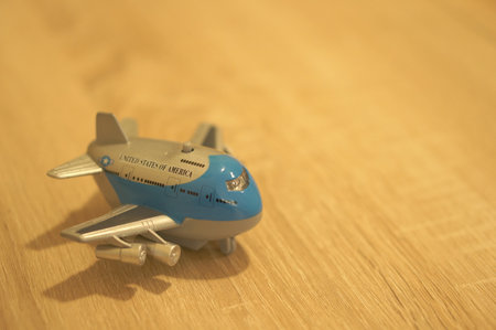 POZNAN, POLAND - Mar 06, 2020: Small plastic toy plane with button on a wooden surface.のeditorial素材