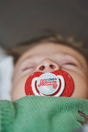 POZNAN, POLAND - Oct 13, 2017: Sleeping baby boy with red pacifier.のeditorial素材