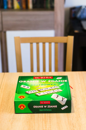 POZNAN, POLAND - Feb 29, 2020: Polish Scriba word game in a green box standing on a wooden table.