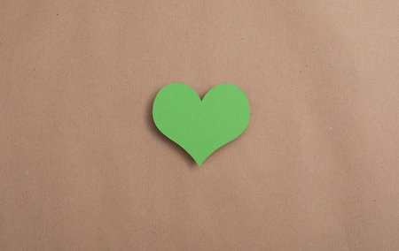 A top view shot of a cute green paper heart - concept of careの写真素材