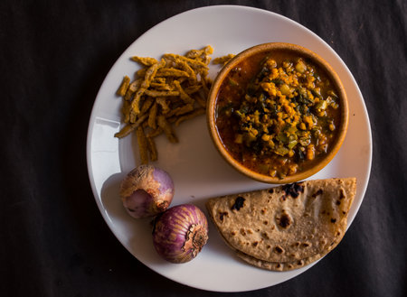 A top view of Indian vegetarian lentil soup served with paratha flatbread
