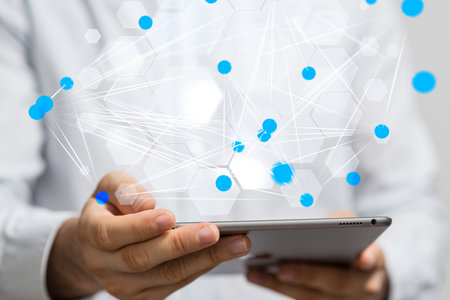 A male hand holding an interface with small circles connected depicting global connectivity data and digital networkの写真素材