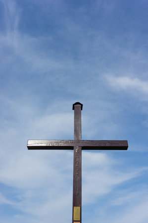 A vertical shot of a cross and a clear blue skyの写真素材