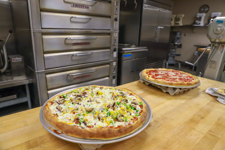 CHICO, UNITED STATES - Mar 03, 2020: Fresh baked pizzas on display at a culinary academy counter.のeditorial素材
