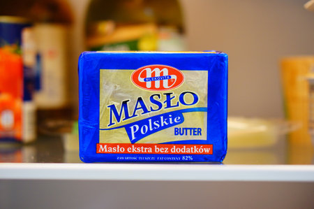 POZNAN, POLAND - Feb 20, 2020: Polish Mlekovita Maslo Polskie butter packed in paper on a glass shelf of a fridge.のeditorial素材