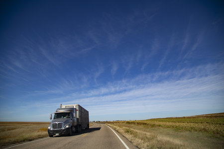 A closeup shot of a truck driving on the empty roads in middle Americaのeditorial素材
