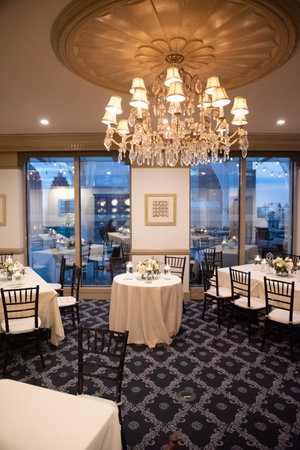 A vertical shot of the hall of an elegant restaurant with white tablecloths on the tablesのeditorial素材