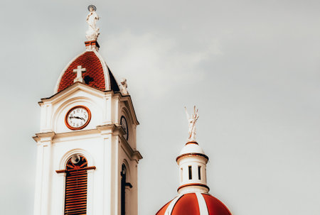 The two towers of the church with clocks and statues on the tops and a grey skyのeditorial素材
