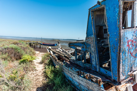 A shot of an old abandoned boat on the low tide shore of Cais PalafÃ­tico da Carrasqueira, Portugalのeditorial素材