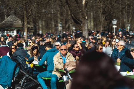 MUNICH, GERMANY - Mar 08, 2020: People in Munich enjoy a fantastic sunny day in winter with a fresh Bavarian beer together with friends in a beer gardenのeditorial素材
